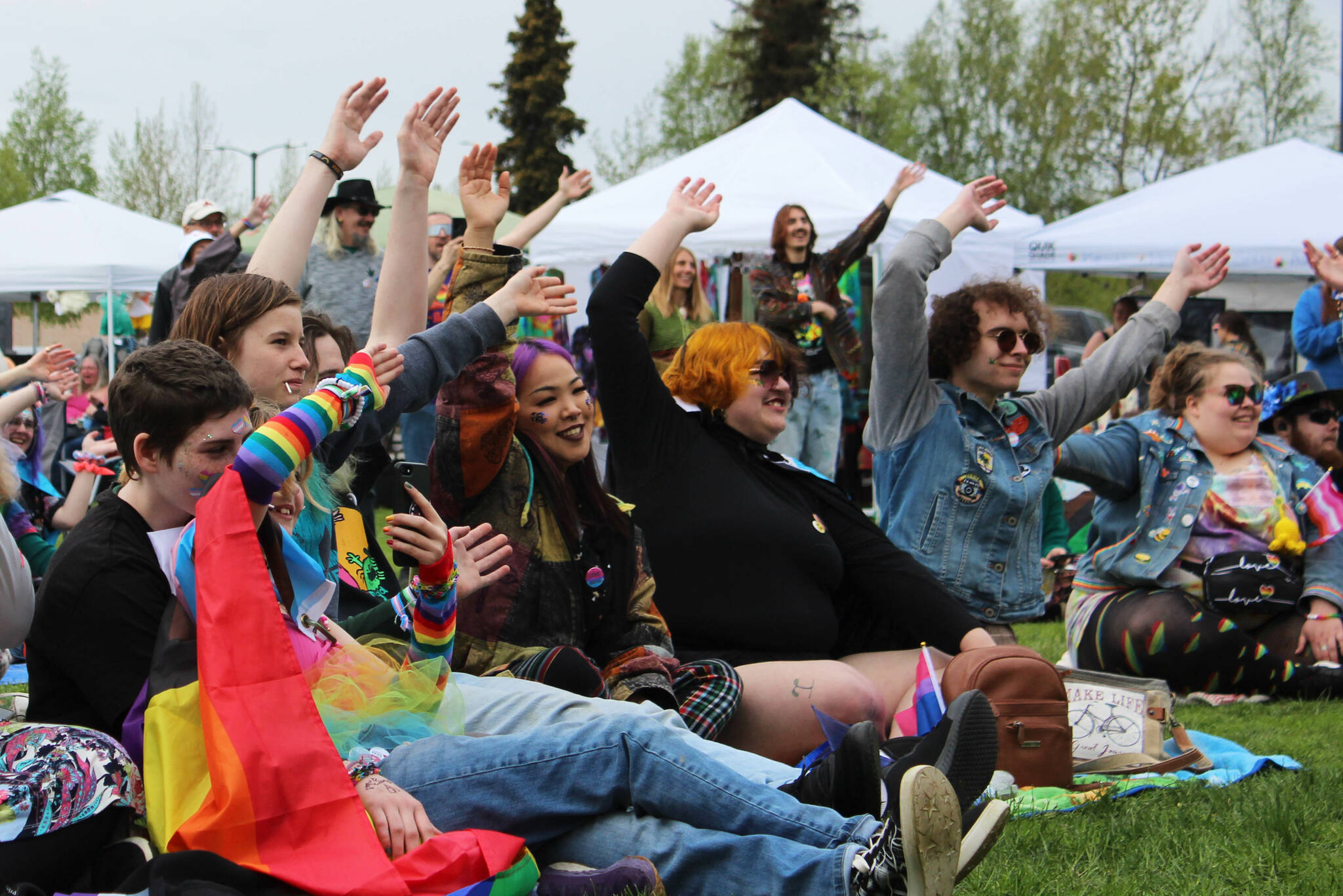 Soldotna Pride in the Park attendees wave their hands during a drag performance at Soldotna Creek Park on Saturday, June 3, 2023 in Soldotna, Alaska. (Ashlyn O’Hara/Peninsula Clarion)