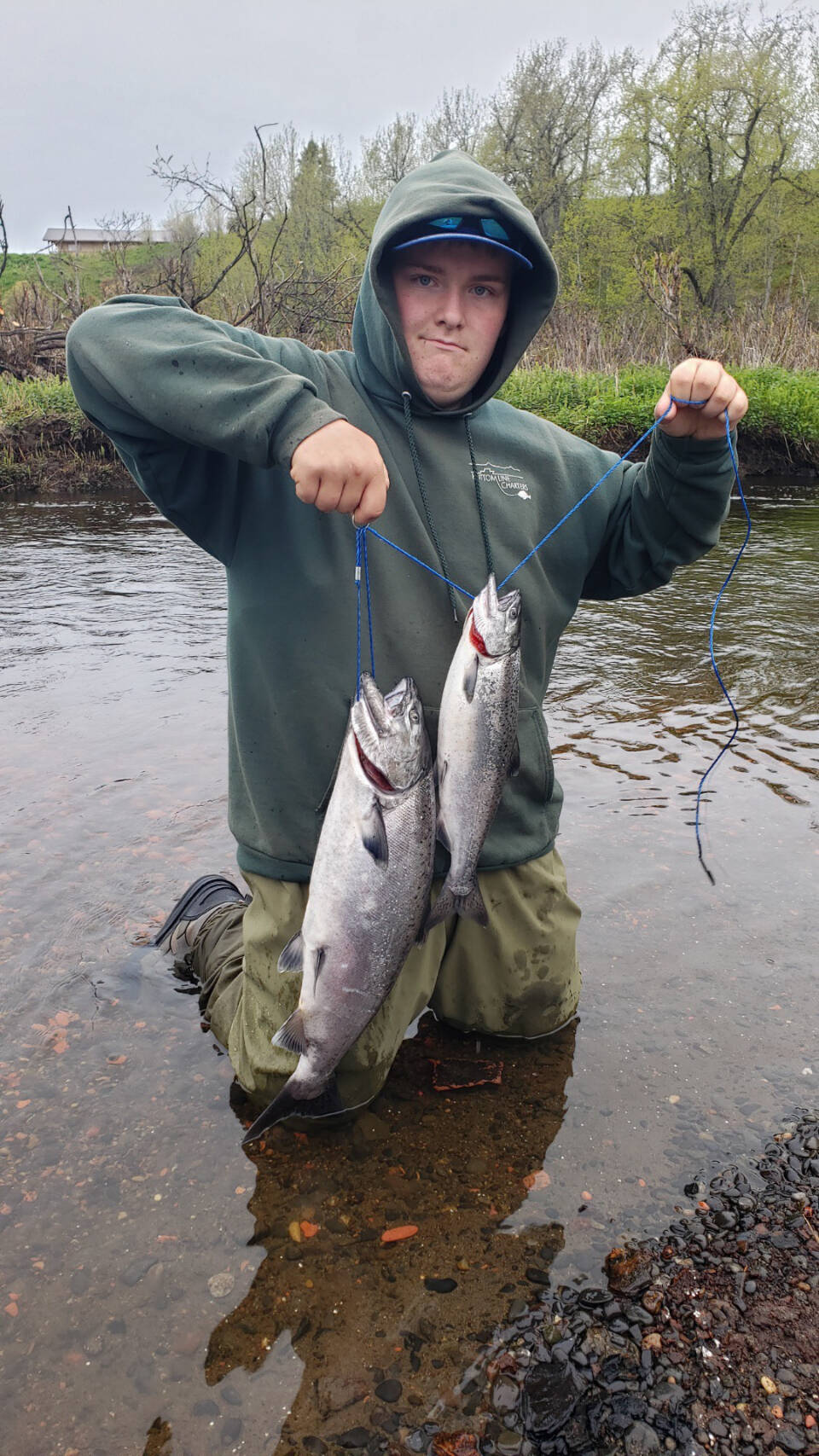 Hunter Kirby holds up the hatchery king salmon he bagged during the one-day youth fishery on the Ninilchik River on Wednesday, June 7, 2023 in Ninilchik, Alaska. Photo by Mike Booz