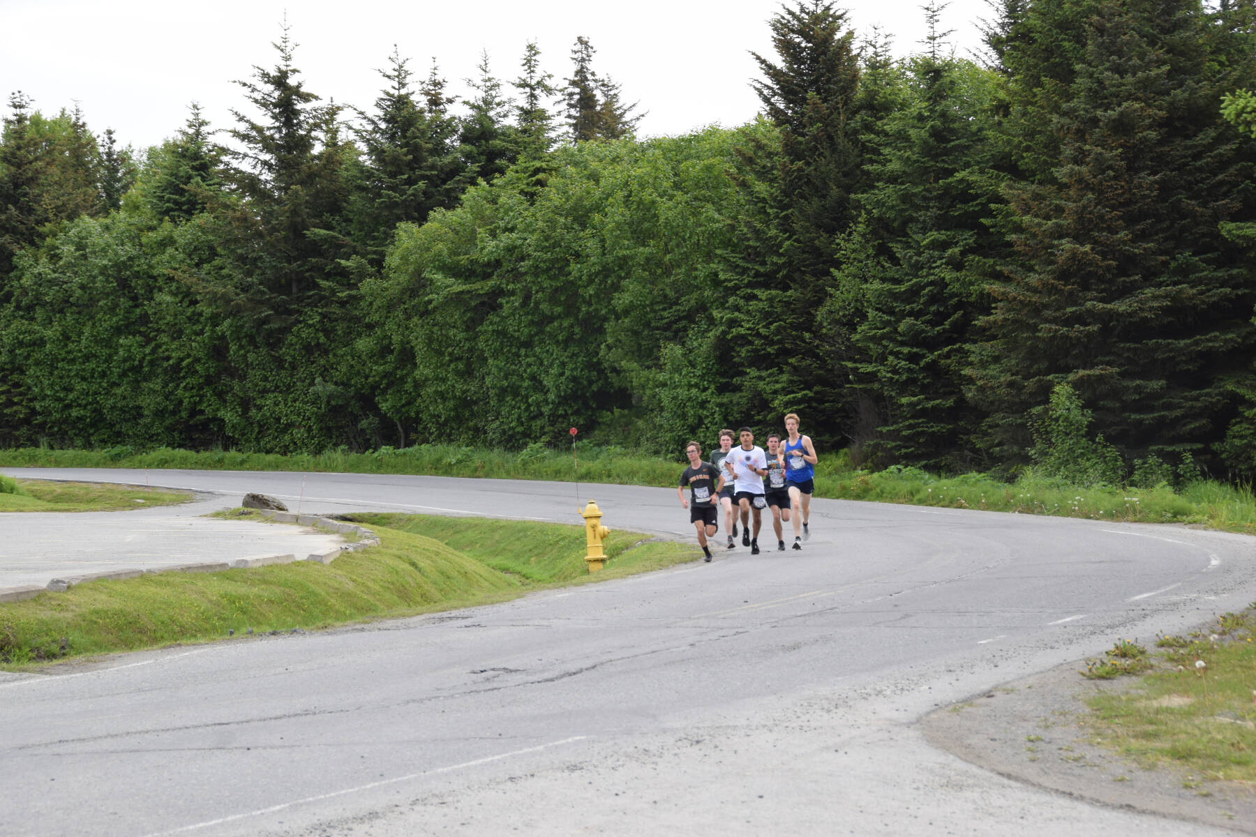 A leading pack of runners participating in the Homer Spit Run 10K to the Bay race round the curve of Ben Walters Lane on Saturday, June 24, 2023 in Homer, Alaska. (Delcenia Cosman/Homer News)