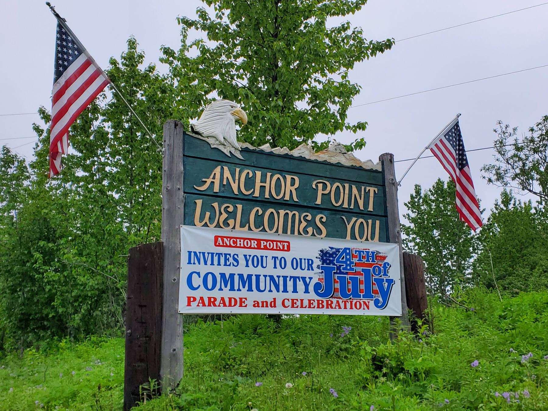 A banner inviting the community to Anchor Point’s annual Fourth of July celebrations is posted by the Sterling Highway heading south on Saturday, June 24, 2023 in Anchor Point, Alaska. (Delcenia Cosman/Homer News)