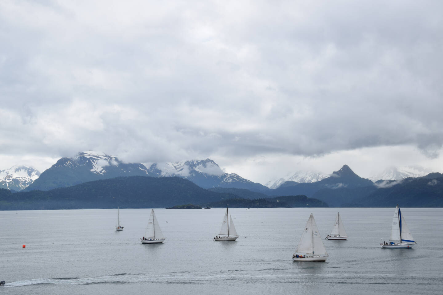 Members of the Homer Yacht Club start the course set for the Homer Yacht Club Regatta on Saturday, June 26, 2023 in the Kachemak Bay below Land’s End Resort in Homer, Alaska. The orange buoy, left, marks the starting point of Saturday’s course, the route of which was revealed to participants minutes before the beginning of the race. (Delcenia Cosman/Homer News)