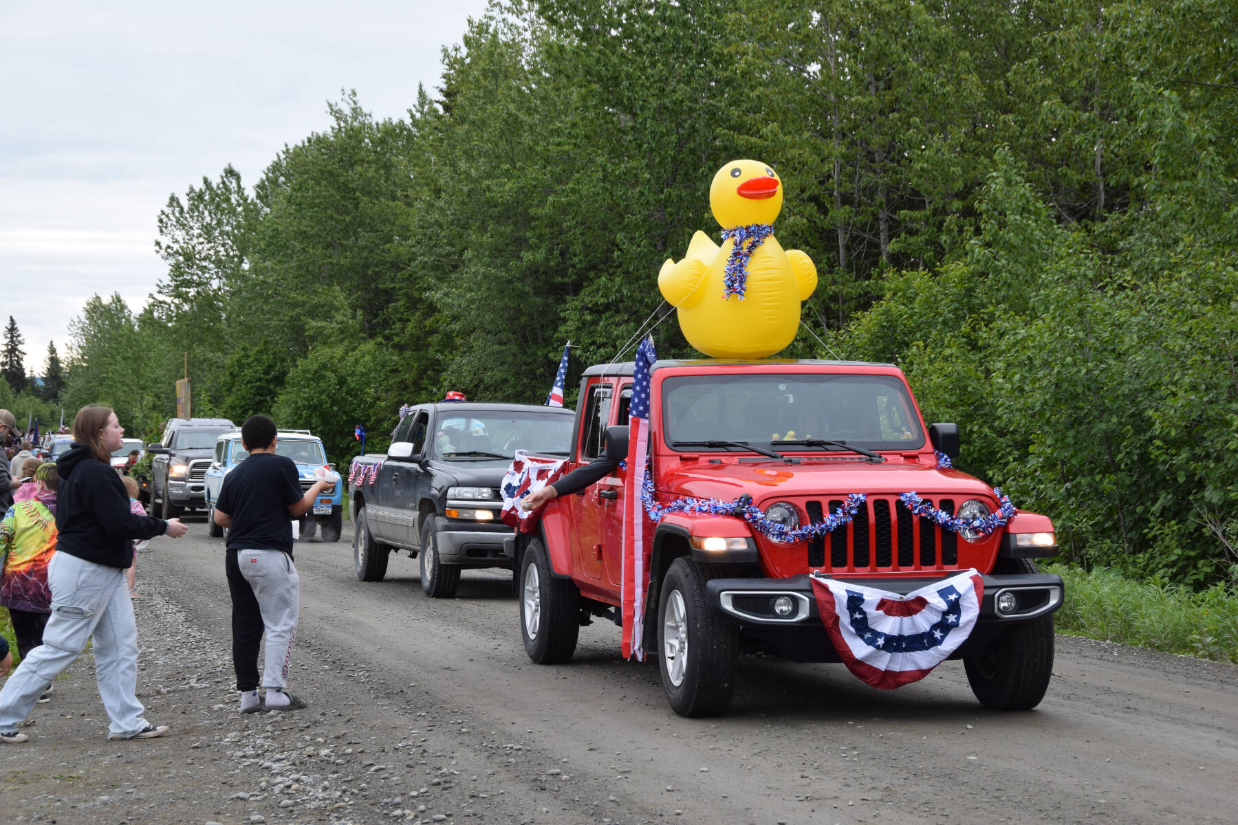Parade participants pass out candy and spectators hand out watermelon slices during the Anchor Point Fourth of July parade on Tuesday, July 4, 2023 in Anchor Point, Alaska. (Delcenia Cosman/Homer News)