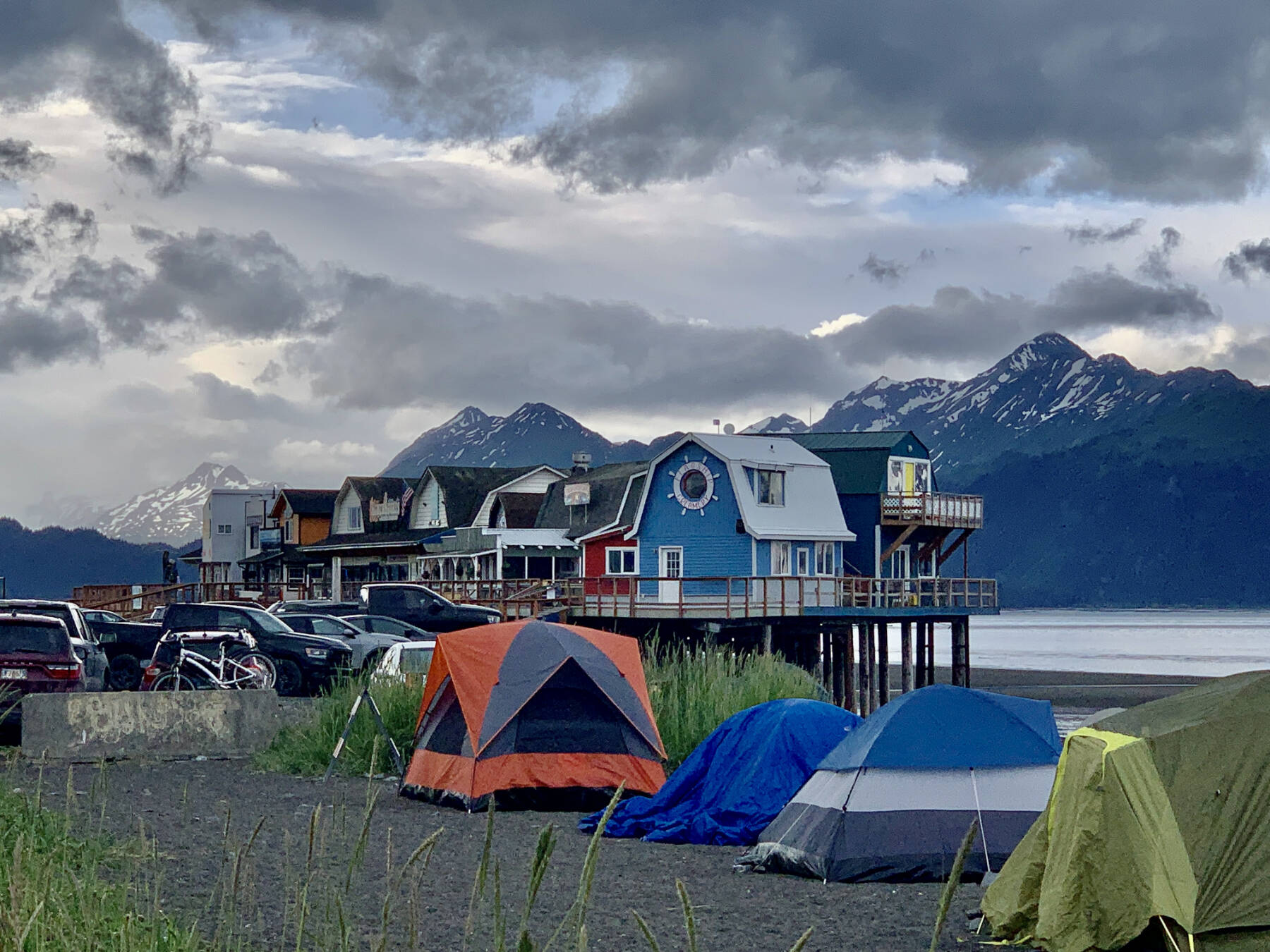Colorful tents are pitched in the foreground of a boardwalk on the Homer Spit during Fourth of July weekend on Sunday, July 2, 2023 in Homer, Alaska. Photo by Christina Whiting