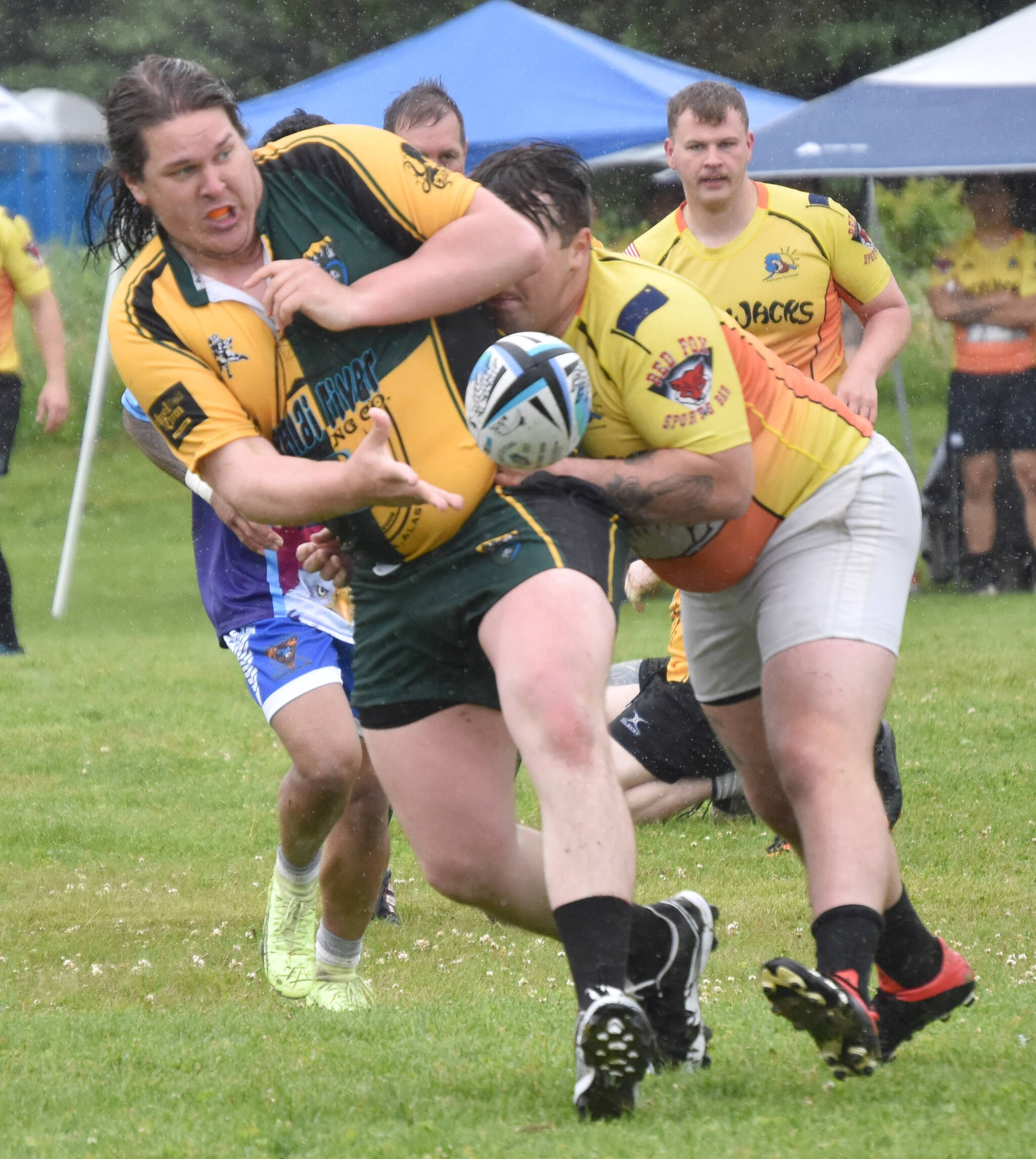Nick Jacuk of the Kenai Wolfpack delivers the ball under pressure against the Fairbanks SunDawgs on Saturday, July 15, 2023, at the Between the Tides Rugby Tourney at Millennium Square Field in Kenai, Alaska. (Photo by Jeff Helminiak)