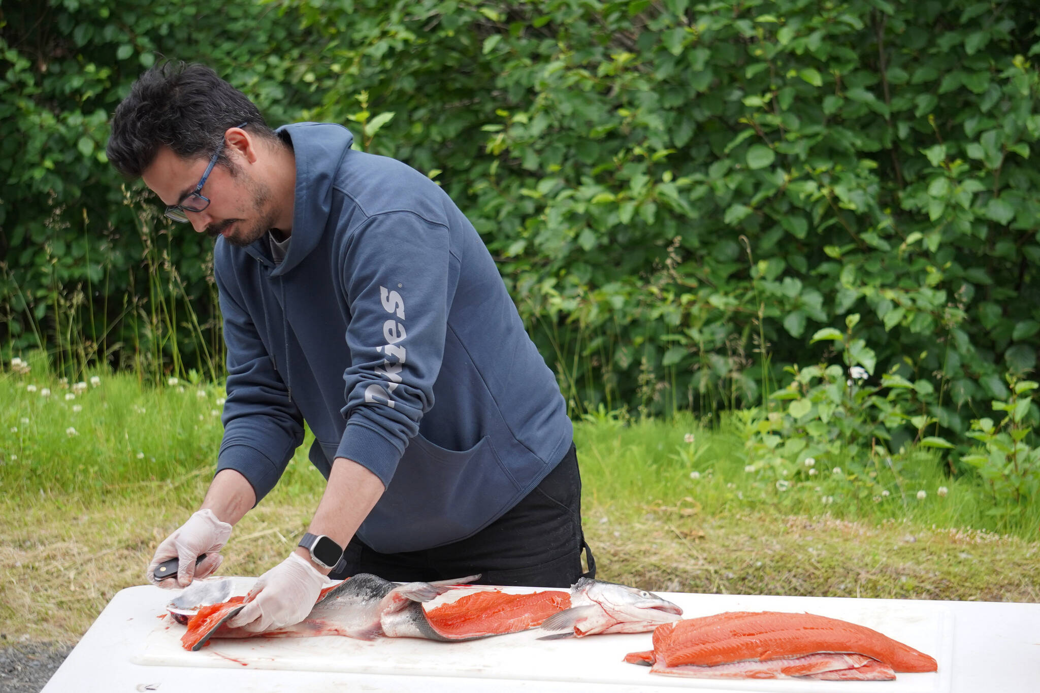 James Wardlow demonstrates filleting a salmon with an ulu during a smoked salmon demonstration, part of Fish Week 2023, on Wednesday, July 19, 2023, at the Kenai National Wildlife Refuge Visitor Center in Soldotna, Alaska. (Jake Dye/Peninsula Clarion)