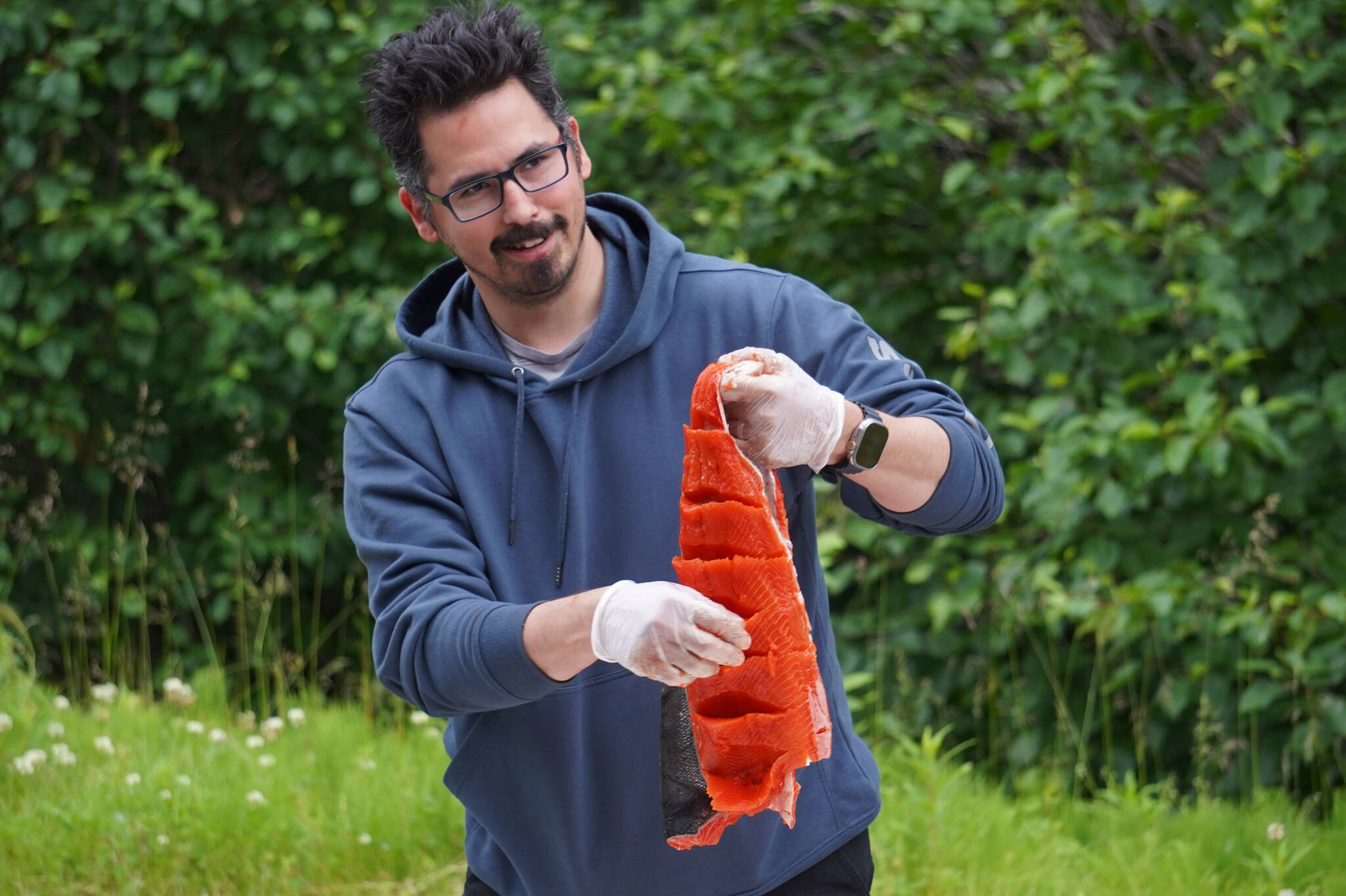 James Wardlow shows off a salmon filet ready to be hung and dried during a smoked salmon demonstration, part of Fish Week 2023, on Wednesday, July 19, 2023, at the Kenai National Wildlife Refuge Visitor Center in Soldotna, Alaska. (Jake Dye/Peninsula Clarion)