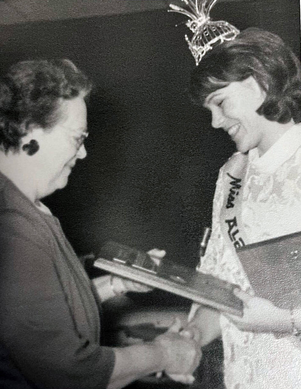 photo courtesy of the Smith Family Collection
Mary Ruth Nidiffer (Miss Alaska 1965) hands Mable Smith a plaque of appreciation for Smith’s service to the Alaska Purchase Centennial Celebration committee.