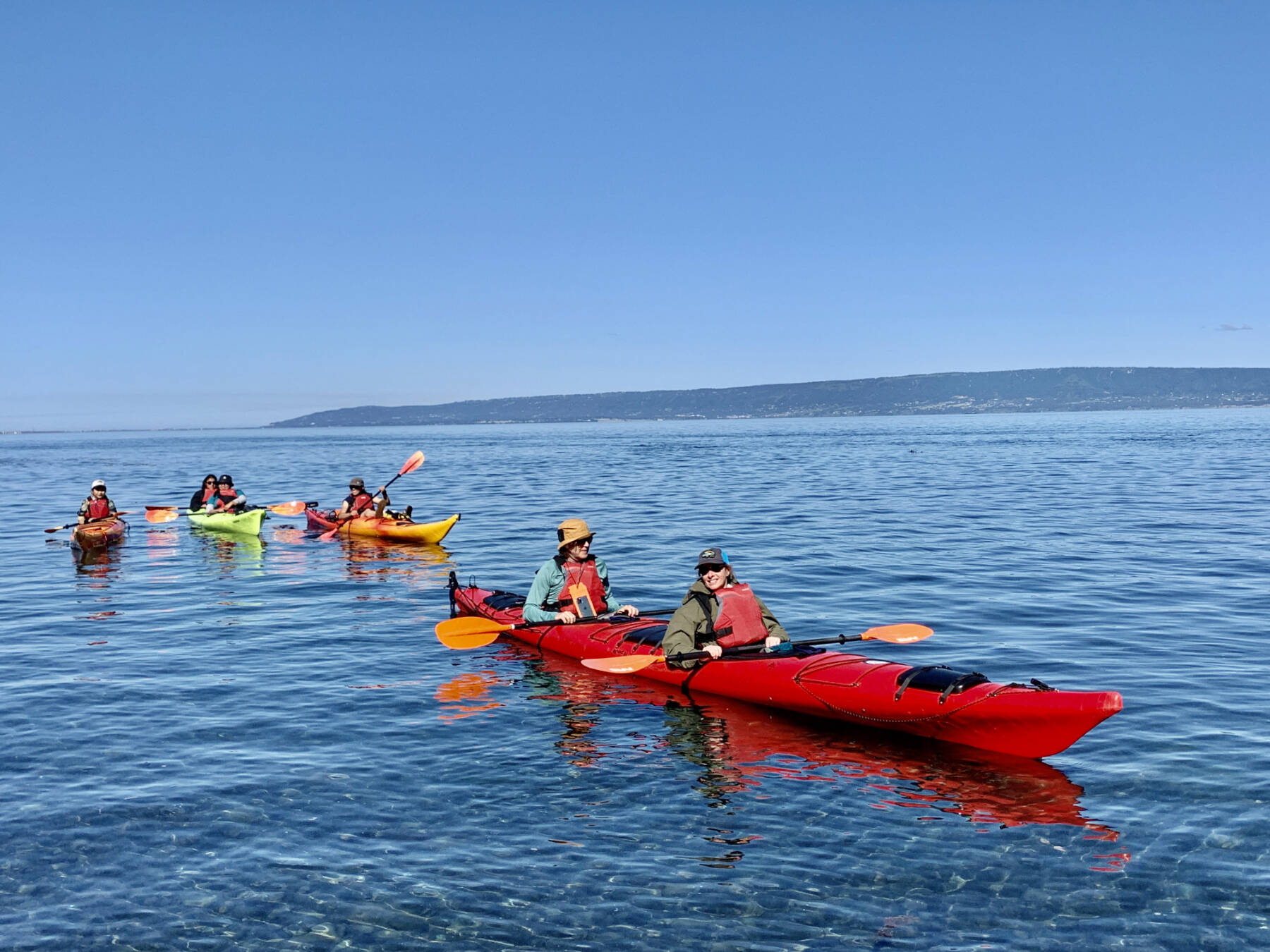 Kayakers enjoy a sunny day as they explore the entrance to Halibut Cove on Tuesday, Aug. 1, 2023 in the Kachemak Bay in Alaska. Photo by Christina Whiting
