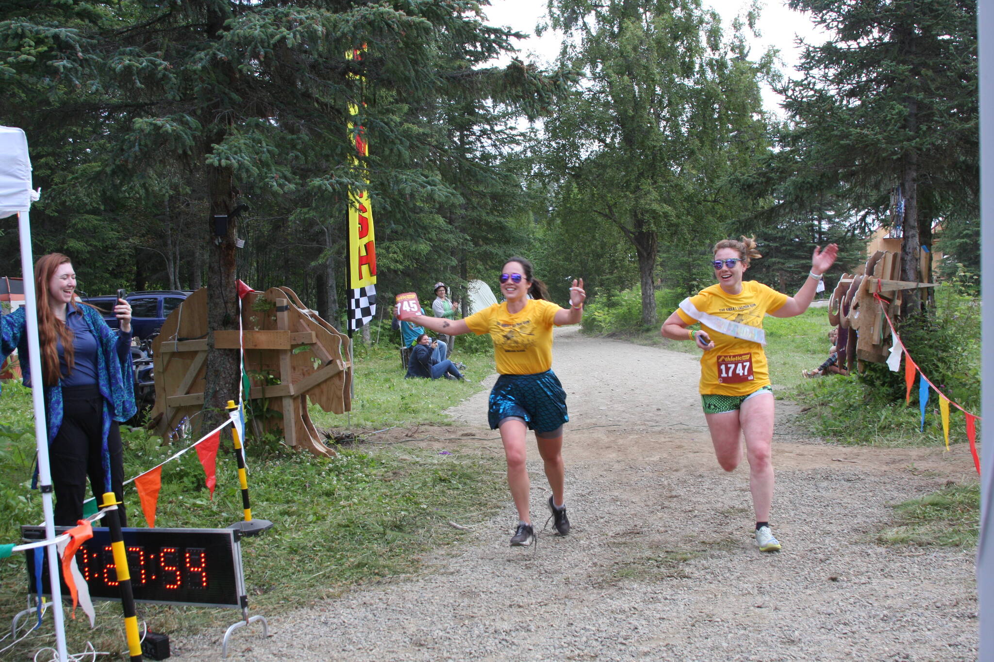 Photos by Delcenia Cosman/Homer News
Sterling Watson, left, and Annie LaBine cross the finish line together in the inaugural Great Salmon Run 5K race on Saturday<ins>, Aug. 5, 2023</ins> during Salmonfest at the Kenai Peninsula Fairgrounds in Ninilchik<ins>,</ins> <ins>Alaska</ins>.
