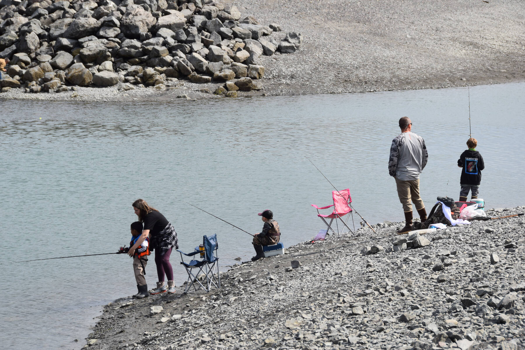 Parents show their kids how to cast their fishing lines during the youth-only coho salmon fishery on Saturday, Aug. 5, 2023 at the Nick Dudiak Fishing Lagoon on the Homer Spit in Homer, Alaska. (Delcenia Cosman/Homer News)