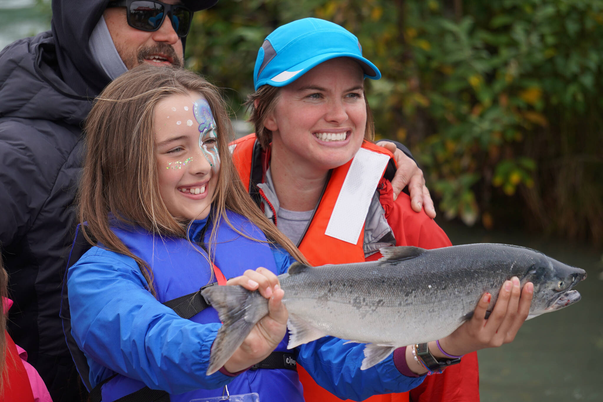 Lillian Bohman holds up a salmon she caught during the Kenai River Junior Classic in Soldotna, Alaska, on Wednesday, Aug. 9, 2023. (Jake Dye/Peninsula Clarion)