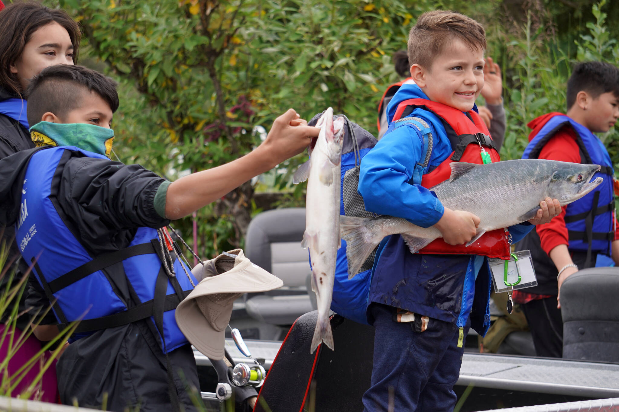 John “Gus” Knox, right, holds a salmon he caught during the Kenai River Junior Classic in Soldotna, Alaska, on Wednesday, Aug. 9, 2023. (Jake Dye/Peninsula Clarion)