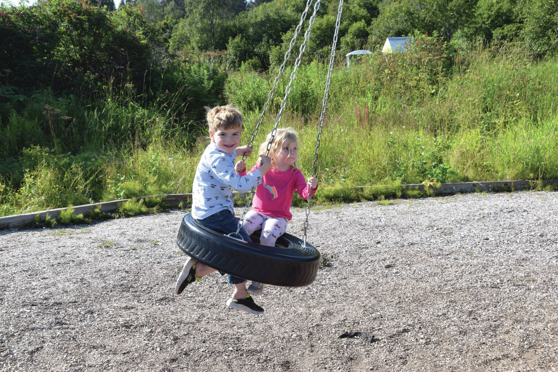 Homer siblings enjoying a ride on the new tire swing at Karen Hornaday Playground on Aug. 17.  Emilie Springer/ Homer News.