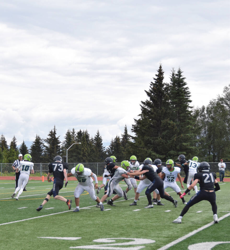 The Mariners varsity football team grapples with the Redington Huskies during the home game on Saturday, Aug. 19, 2023 in Homer, Alaska. (Emilie Springer/Homer News)
