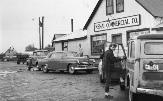 [1a—] After doing business in the Kenai Commercial Company store, Rusty Lancashire climbs into family station wagon, with its sagging back bumper, to head for home. (1954 photo by Bob and Ira Spring for Better Homes & Garden magazine)