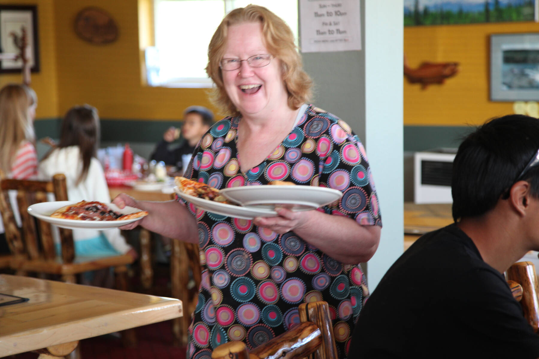 Co-owner and operator, Carol Cameron, serves pizza to customers at Rosco’s Pizza in Ninilchik, Alaska. Photo provided by Ross Cameron