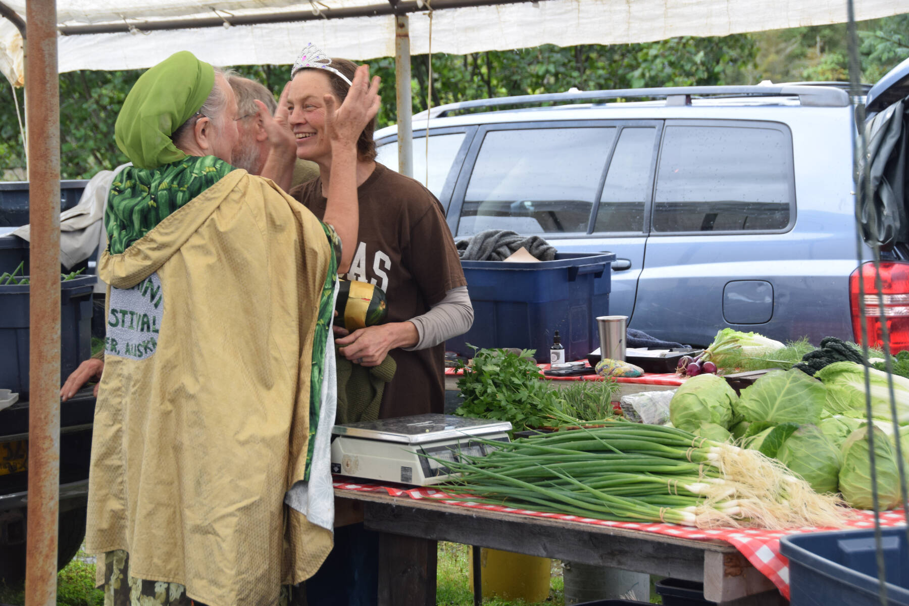 Reigning “Zucchini Queenie” Luba Dorvall (left) crowns the new queen, Jen Castellani (right), at the Homer Farmers Market Zucchini Festival on Saturday, Aug. 26, 2023 in Homer, Alaska. (Delcenia Cosman/Homer News)