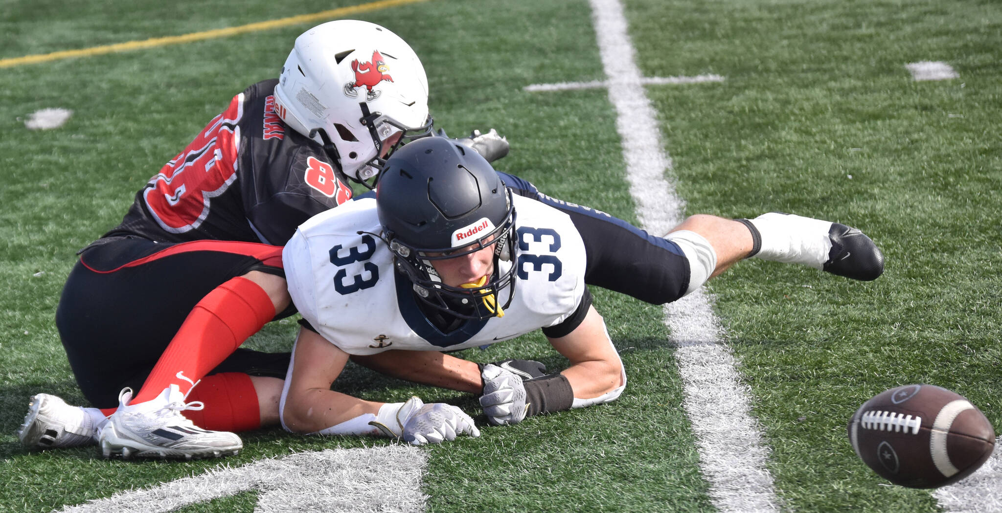 Homer’s Jake Tappan is taken down by Kenai Central’s Sawyer Vann while a live ball lies on the field Saturday, Sept. 2, 2023, at Ed Hollier Field at Kenai Central High School in Kenai, Alaska. The Kardinals would recover the ball. (Photo by Jeff Helminiak/Peninsula Clarion)