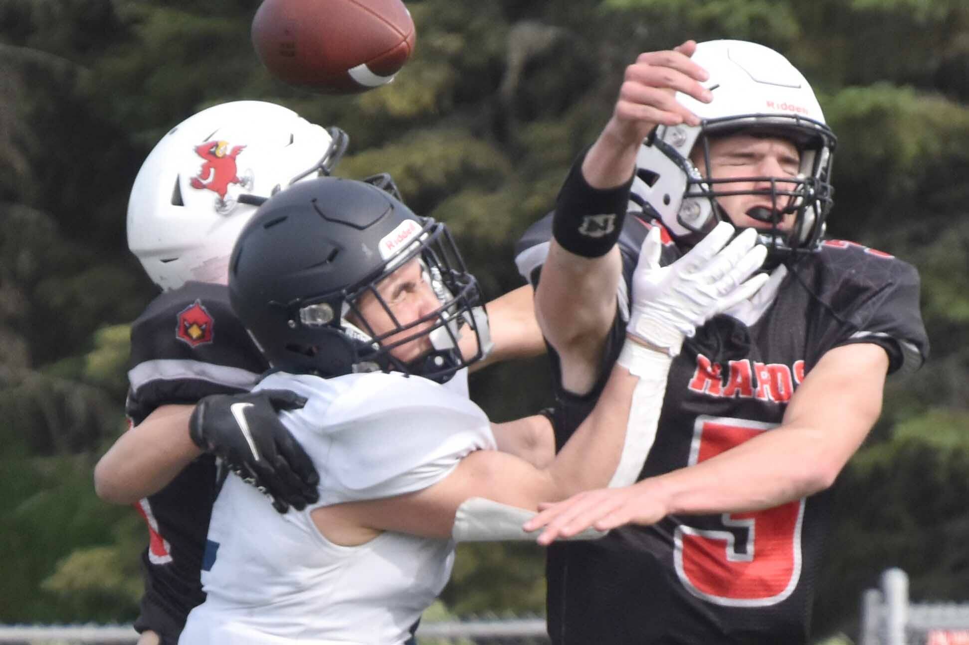 Kenai Central's Sawyer Vann and Zeke Yragui break up a pass intended for Homer's Chris Martishev on Saturday, Sept. 2, 2023, at Ed Hollier Field at Kenai Central High School in Kenai, Alaska. (Photo by Jeff Helminiak/Peninsula Clarion)
