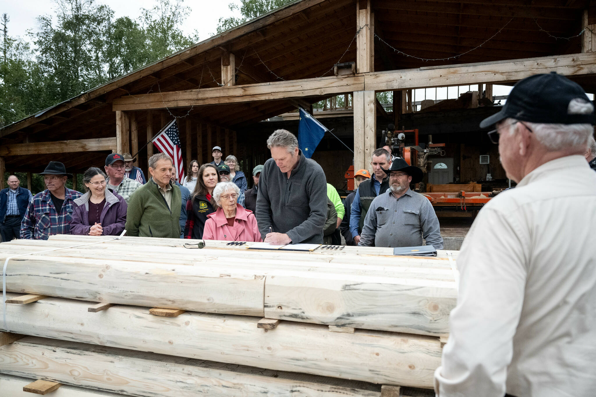 Photo courtesy Gov. Mike Dunleavy’s Office
Gov. Mike Dunleavy signs S.B. 7 into law at Papoose Milling on Wednesday in Big Lake.
