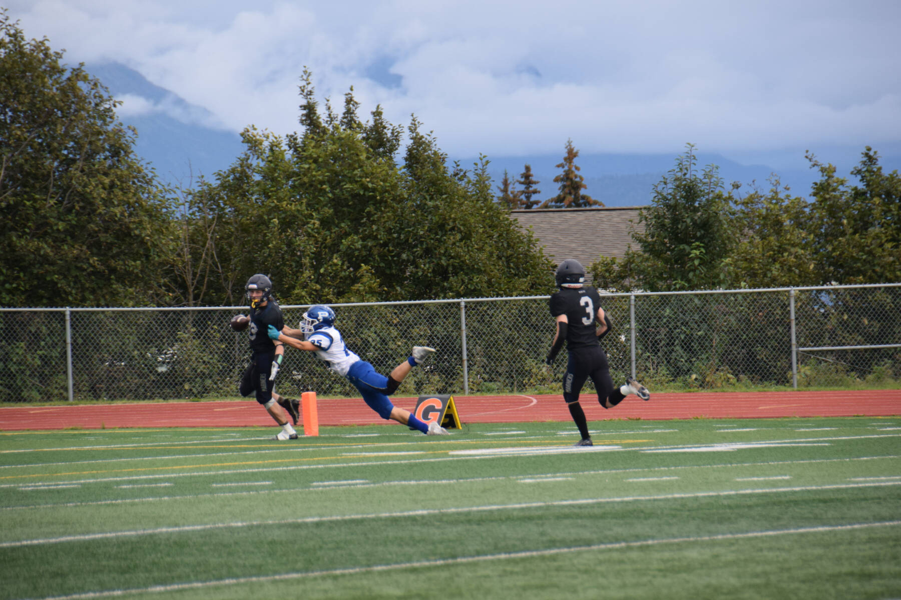 Jake Tappan (left) runs toward the end zone, breaking out of a tackle by Palmer’s Owen Lance to score a touchdown for the Mariners at the homecoming game versus Palmer on Friday, Sept. 8, 2023 in Homer, Alaska. (Delcenia Cosman/Homer News)