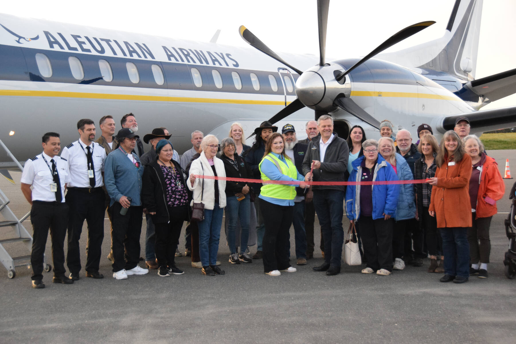 Alaska general manager Brian Whilden (center right) and Homer station manager Ashley Appel (center left) pose with flight staff and community members during a ribbon-cutting ceremony for Aleutian Airways at the Homer Airport on Tuesday, Sept. 19, 2023 in Homer, Alaska. (Delcenia Cosman/Homer News)