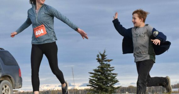 Amy Anderson gets encouragement from her son, Everett, in the marathon relay at the Kenai River Marathon on Sunday, Sept. 24, 2023, in Kenai, Alaska. Anderson teamed with Bethany Nyboer, Katy Coseglia and Chelsea Wingard to finish fourth with Soar B.A.C.K.'s. (Photo by Jeff Helminiak/Peninsula Clarion)