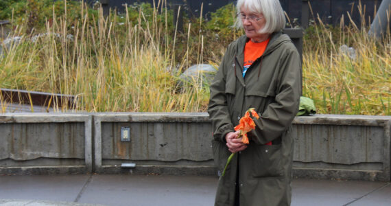 Mary Hunt, a survivor of Holy Cross Mission, holds flowers during an Orange Shirt Day ceremony at Ggugguyni T'uh, "Raven Place," outside the Dena'ina Wellness Center on Friday, Oct. 6, 2023 in Kenai, Alaska. Orange Shirt Day honors indigenous elders who survived and children lost from boarding schools established to detribalize indigenous people. (Ashlyn O'Hara/Peninsula Clarion)