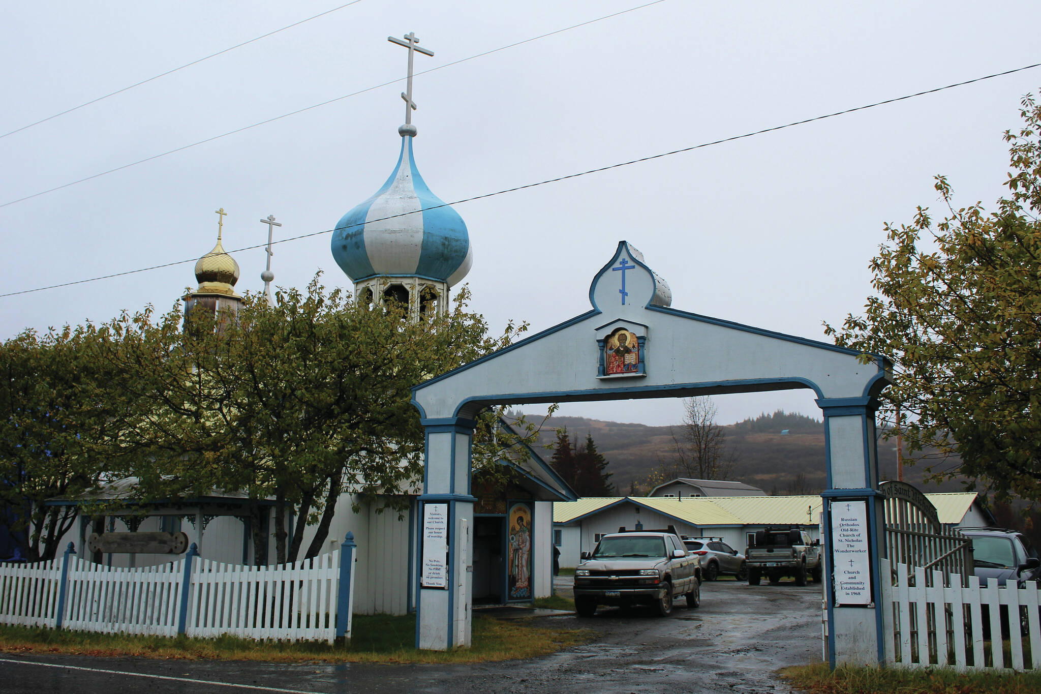 Ashlyn O’Hara/Peninsula Clarion
An arch marks the entrance to the Church of St. Nicholas on Oct. 10 in Nikolaevsk. In rear, cars are parked in front of a building that has been used this school year as a makeshift classroom for families who are part of a home-school cooperative.