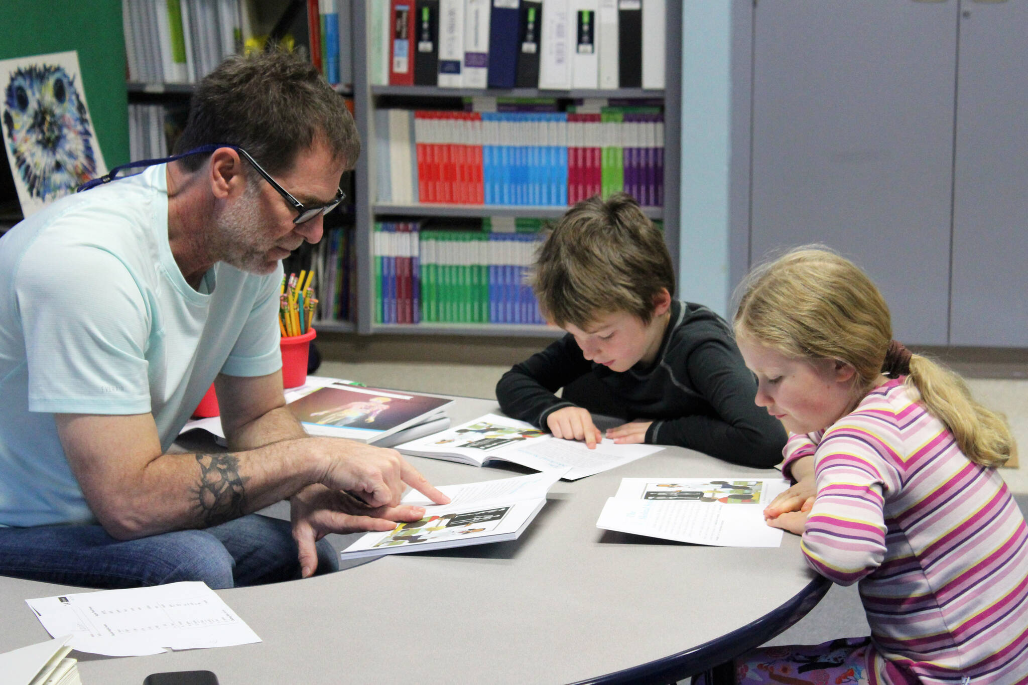Hope School K-5 teacher Jeremy McKibben assists third grade students with reading skills part of CKLA’s “How Does Your Body Work?” unit on Wednesday, Oct. 18, 2023, in Hope, Alaska. (Ashlyn O’Hara/Peninsula Clarion)