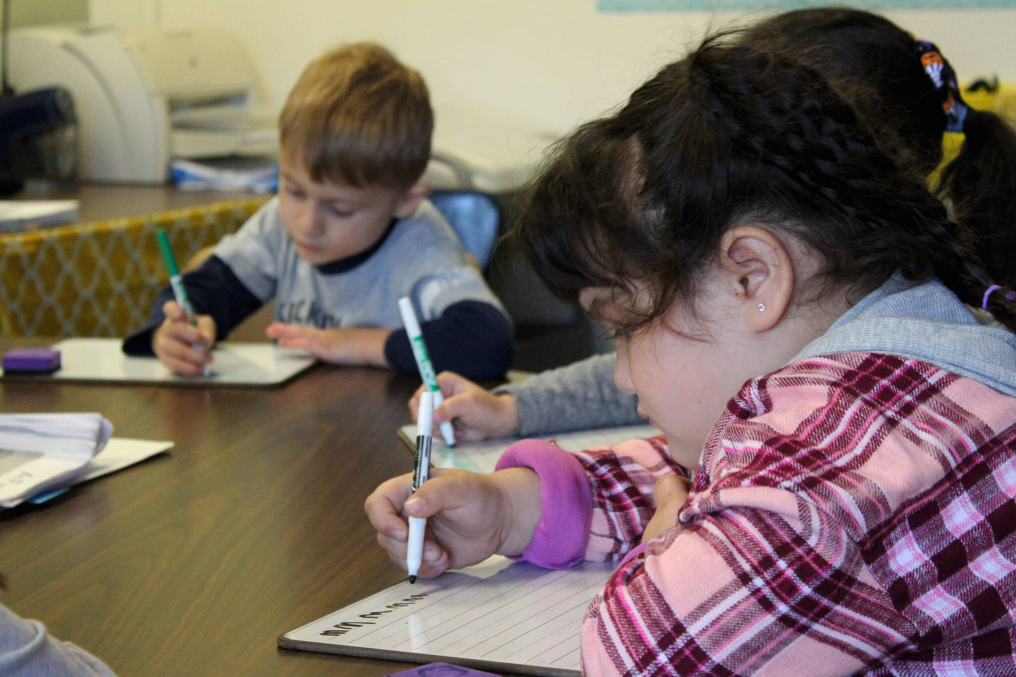 Students practice writing the letter “M” during a group activity led by Mountain View Elementary School Interventionist Katie Schneider on Thursday, Oct. 19, 2023, in Kenai, Alaska. (Ashlyn O’Hara/Peninsula Clarion)