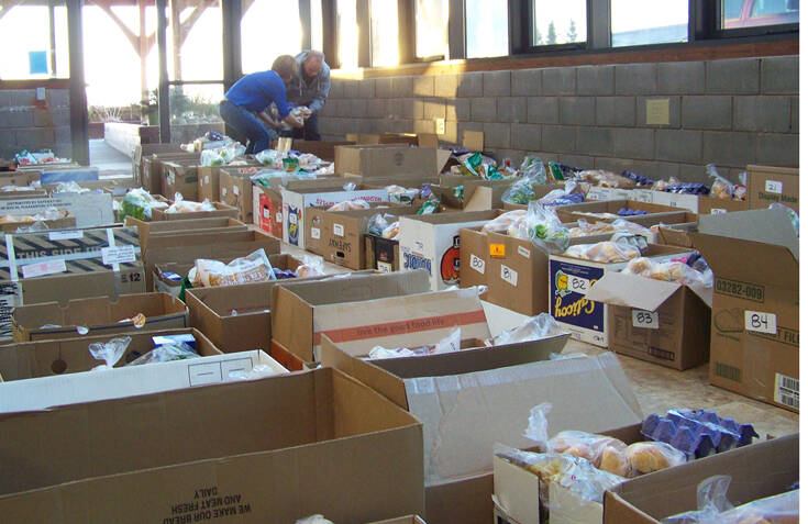 Volunteers help organize more than 200 boxes of food Saturday morning, part of the Lions Club Thanksgiving Basket program. Homer News file photo.