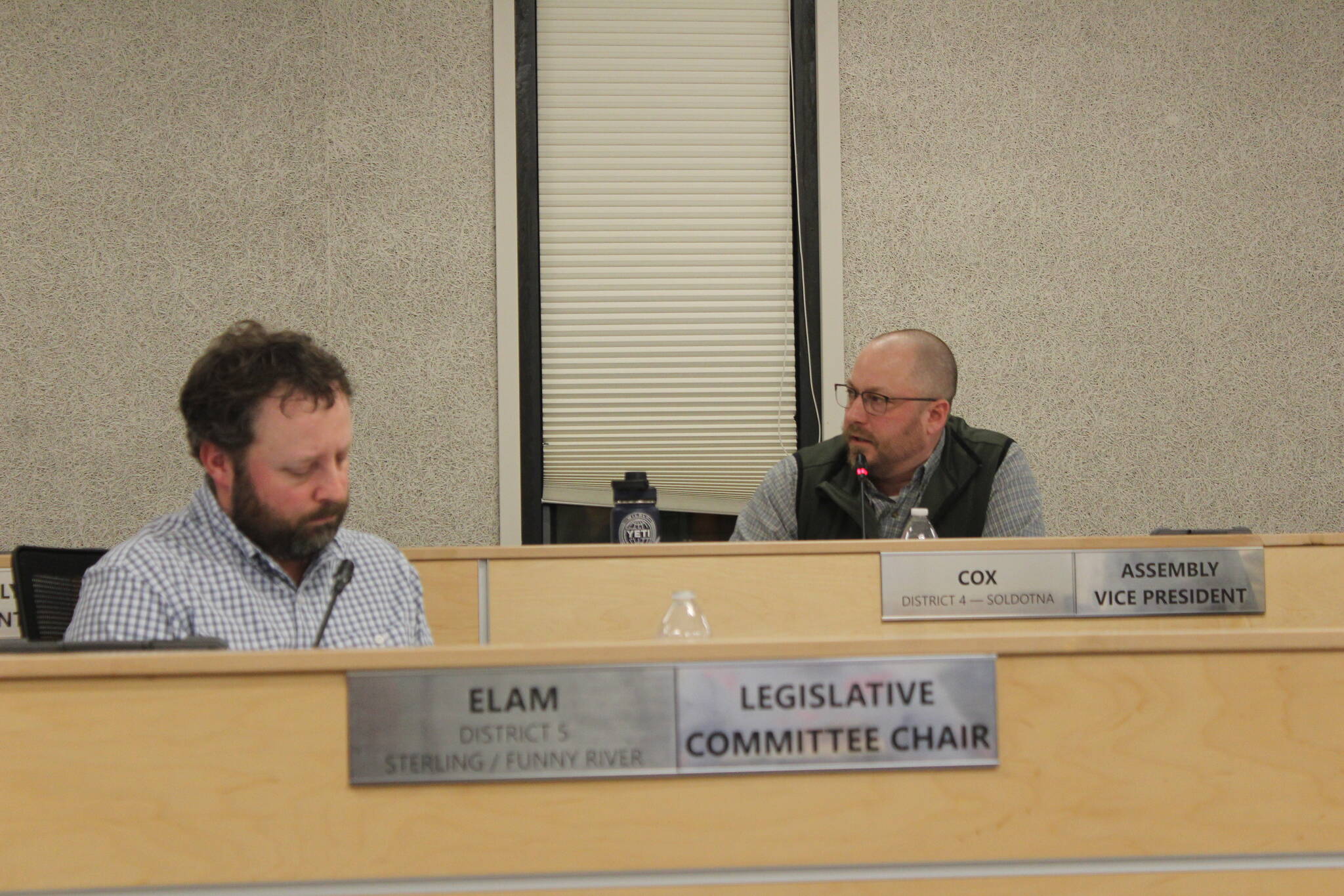 Assembly members Bill Elam, left, and Tyson Cox, right, discuss during a Kenai Peninsula Borough Assembly meeting a resolution only permitting certain chaplains to deliver invocations before borough assembly meetings on Tuesday, Nov. 7, 2023 in Soldotna, Alaska. (Ashlyn O’Hara/Peninsula Clarion)