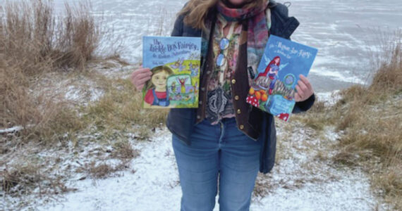 Homer resident Sally Wills poses with her recent publication “The Tackle Box Fairies” at the Homer News in Homer, Alaska, in early November. (Emilie Springer/ Homer News)