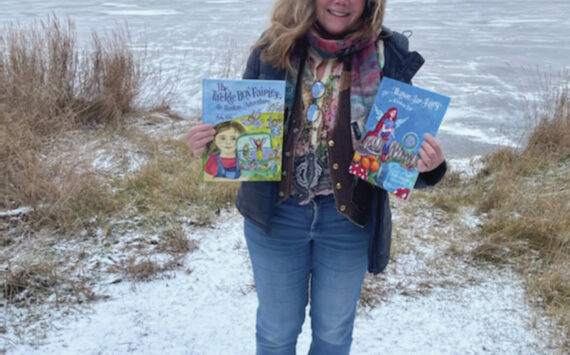 Homer resident Sally Wills poses with her recent publication “The Tackle Box Fairies” at the Homer News in Homer, Alaska, in early November. (Emilie Springer/ Homer News)