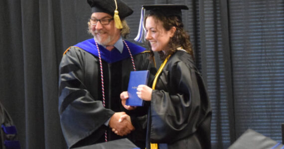Kachemak Bay Campus Director Dr. Reid Brewer (left) presents valedictorian Elizabeth Rozeboom (right) with her Associate of Arts diploma during the 2023 KBC Commencement on Wednesday, May 10, 2023 in Homer, Alaska. Photo by Delcenia Cosman