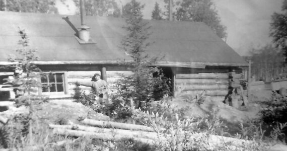 Photo courtesy of the Bodnar Family Collection
In about 1948, after he and brother Alex had proven up on his homestead and were in the process of proving up on Alex’s, Marcus Bodnar poses here with his cabin along the Kenai River near the site of the bridge, which was just being built at this time.