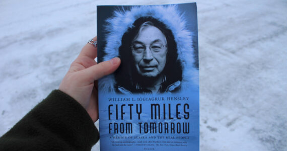 A copy of William L. Iġġiaġruk Hensley’s “Fifty Miles from Tomorrow” is held outside the Peninsula Clarion building on Tuesday, Dec. 12, 2023 in Kenai, Alaska. (Ashlyn O’Hara/Peninsula Clarion)