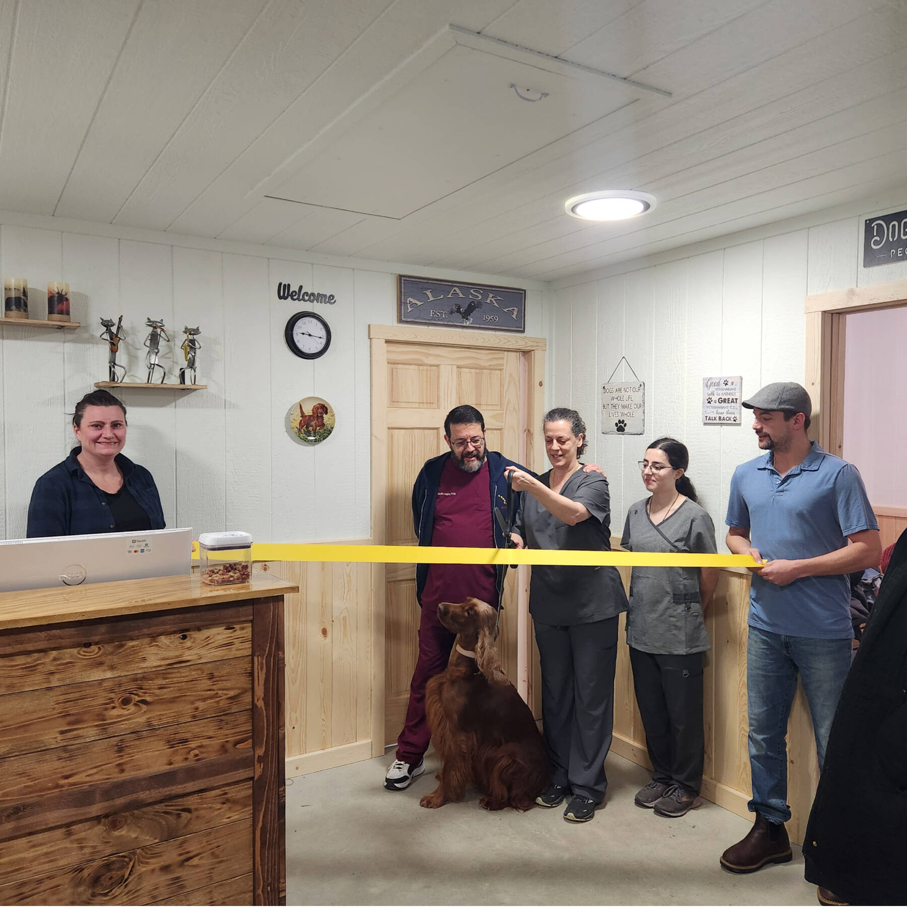 Anchor Point Chamber of Commerce vice president Erin Jerde (left) and president Dawson Slaughter (right) hold the ribbon as Aisha Lagoa (center) prepares to cut it during an opening ceremony for Chugach Animal Clinic on Thursday, Jan. 25, 2024 in Anchor Point, Alaska. Photo provided by Amanda Jerde
