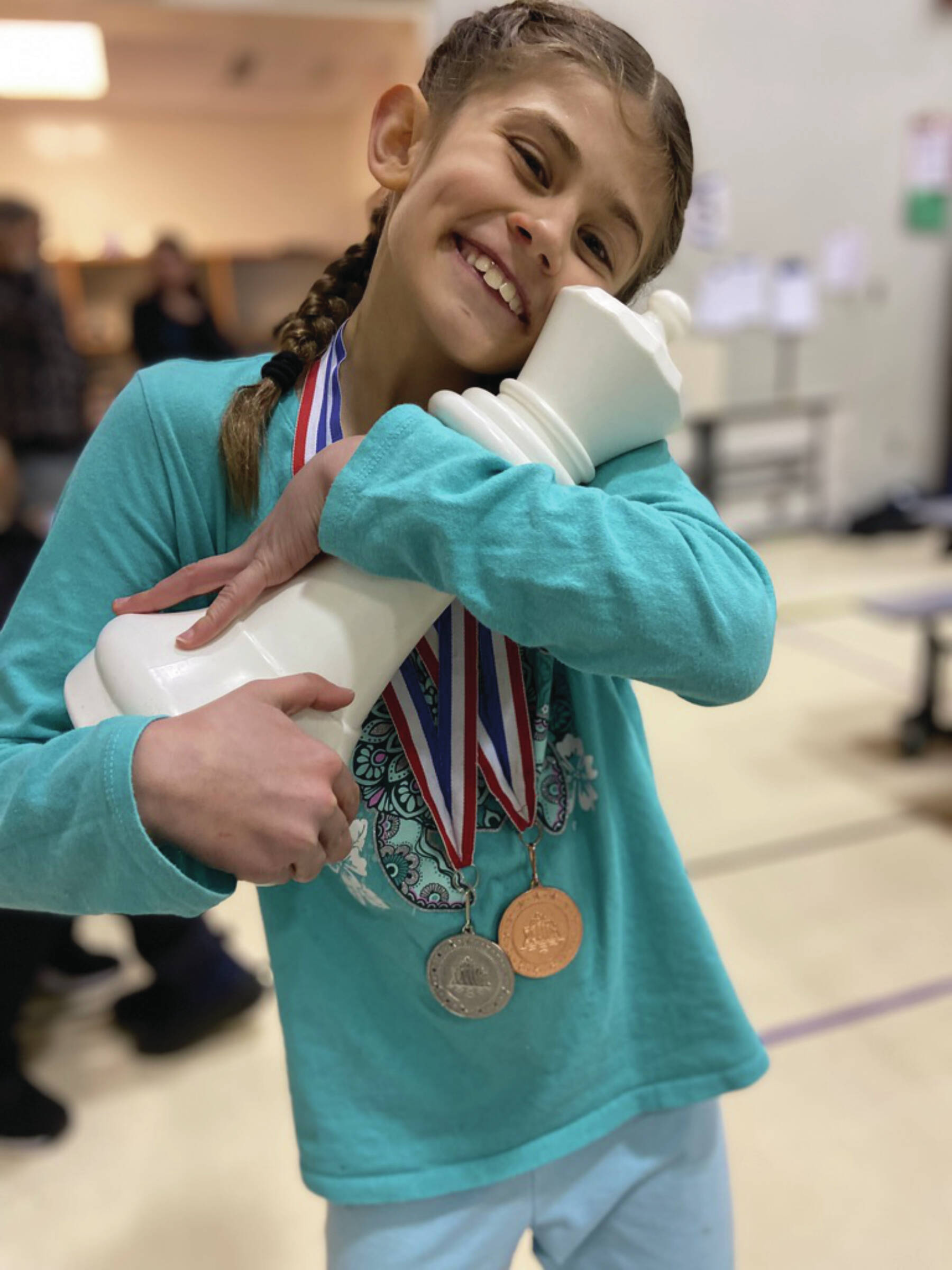 Photo provided by Andy Haas
Evelyn Field embraces a chess piece at the tournament at West Homer Elementary on Monday.