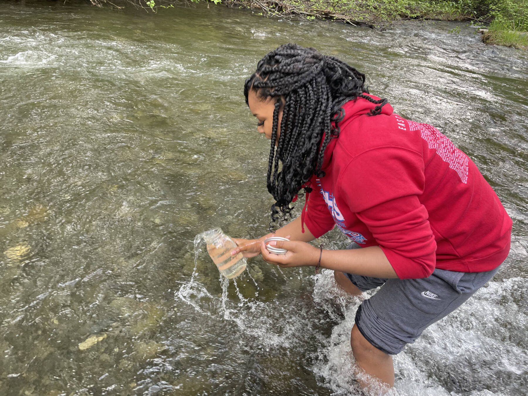 University of Alaska Southeast SeaGrant fellow Joi Gross takes water samples from Campbell Creek in the summer of 2023 in Anchorage, Alaska. Photo provided by Dyani Chapman