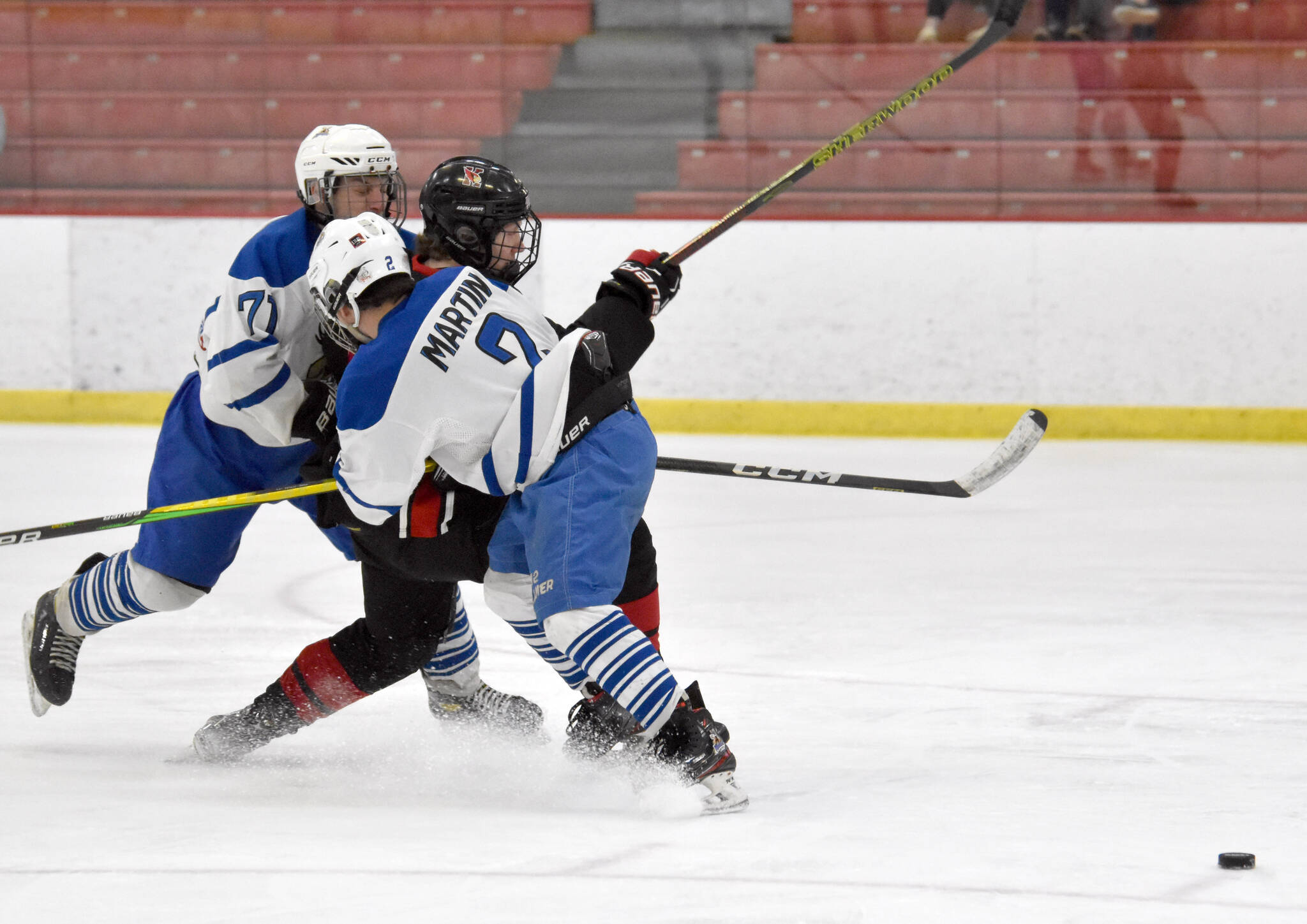 Palmer’s Nathanael Wright and Ryan Martin keep Kenai Central’s Avery Martin from getting the puck at the Division II state hockey tournament Saturday, Feb. 3, 2024, at the Soldotna Regional Sports Complex in Soldotna, Alaska. (Photo by Jeff Helminiak/Peninsula Clarion)
