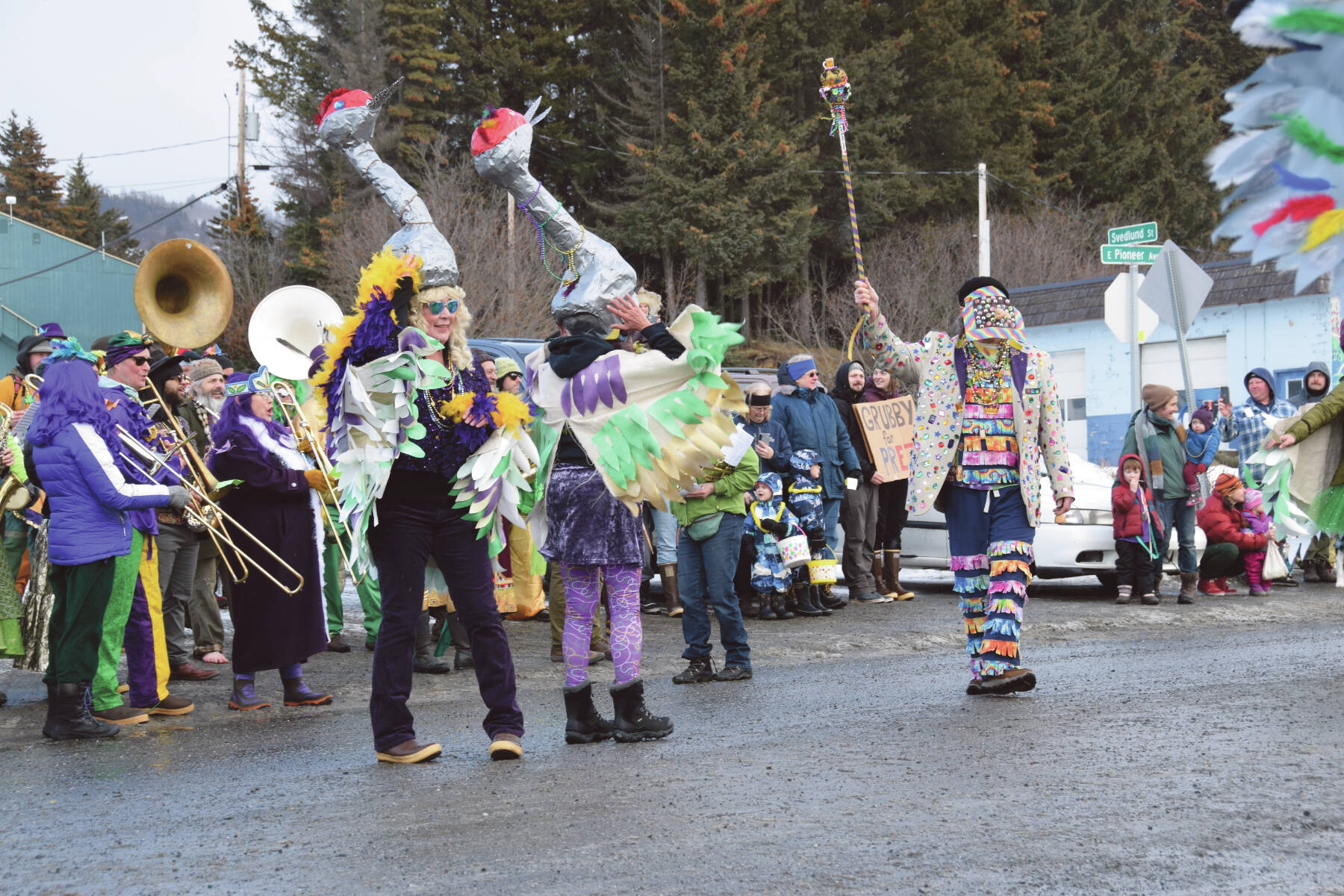 Costumed members of the Krewe of Gambrinus dance to their band playing “Celebration” in the background at the 70th annual Homer Winter Carnival Parade on Pioneer Avenue on Saturday, Feb. 10, 2024 in Homer, Alaska. (Delcenia Cosman/Homer News)