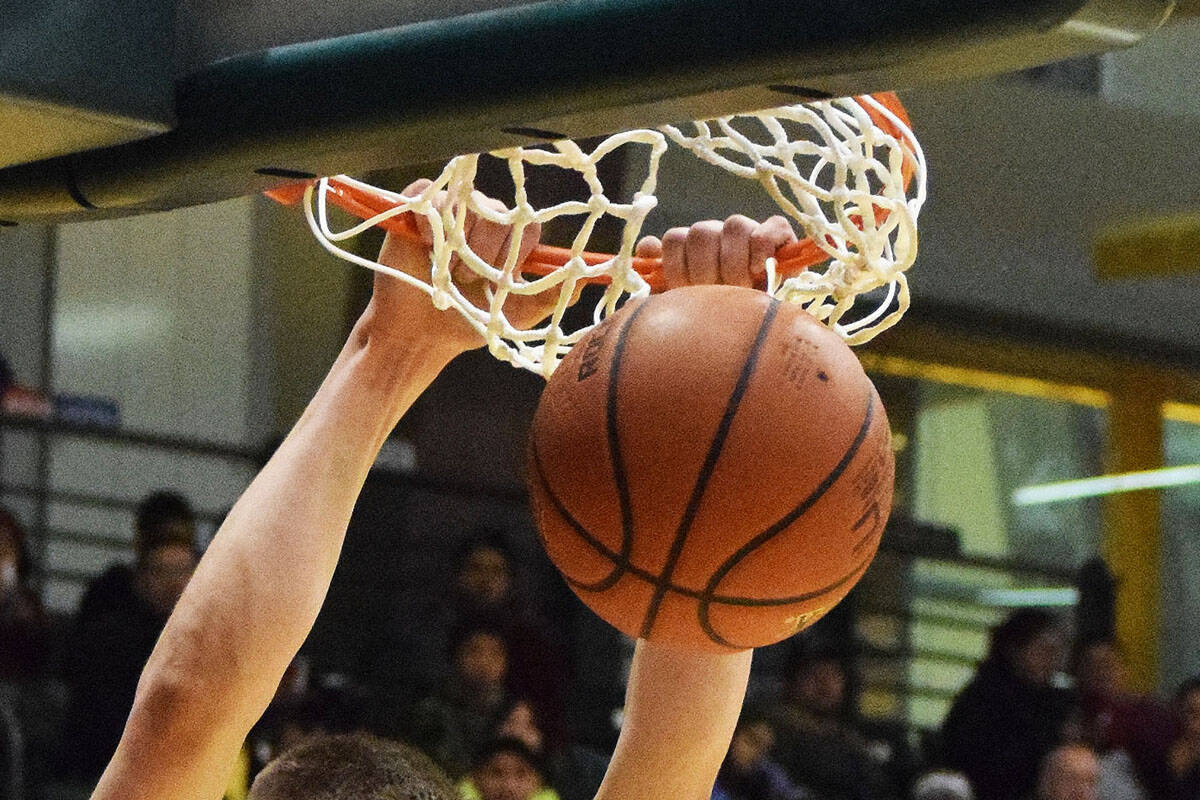 Ninilchik's Austin White puts down a two-handed dunk against the Aniak Halfbreeds Wednesday at the Class 1A state basketball tournament at the Alaska Airlines Center in Anchorage. (Photo by Joey Klecka/Peninsula Clarion)