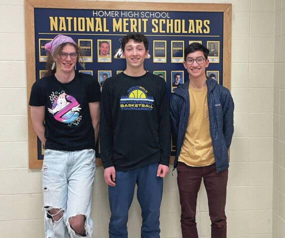 Photo by Emilie Springer
Seniors Blaise Banks, Lucas Story and Spencer Co receive recognition in annual National Merit Scholarship program and stand next to the display of past Homer High awardees at Homer High School on Tuesday March 19.