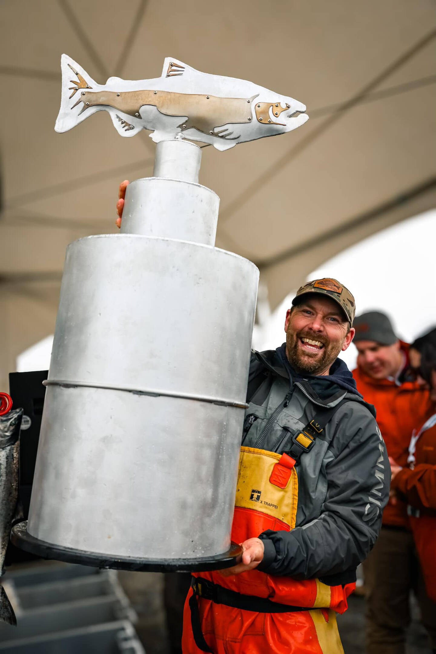 Chris Keithley, 2024 Homer Winter King Salmon Tournament champion, hoists up the new championship trophy crafted by Bay Weld Boats after the awards ceremony at the Deep Water Dock on the Spit in Homer, Alaska on Saturday, March 23, 2024. Photo by Misty Kincaid.