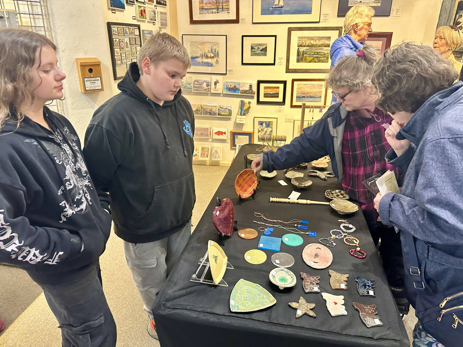 Community members browse art by local youth artists including Rileah and Colin Sims (left), both aged 11, at the Ptarmigan Arts Youth Arts Pop Up on Friday, April 5, 2024 in Homer, Alaska. Photo by Christina Whiting