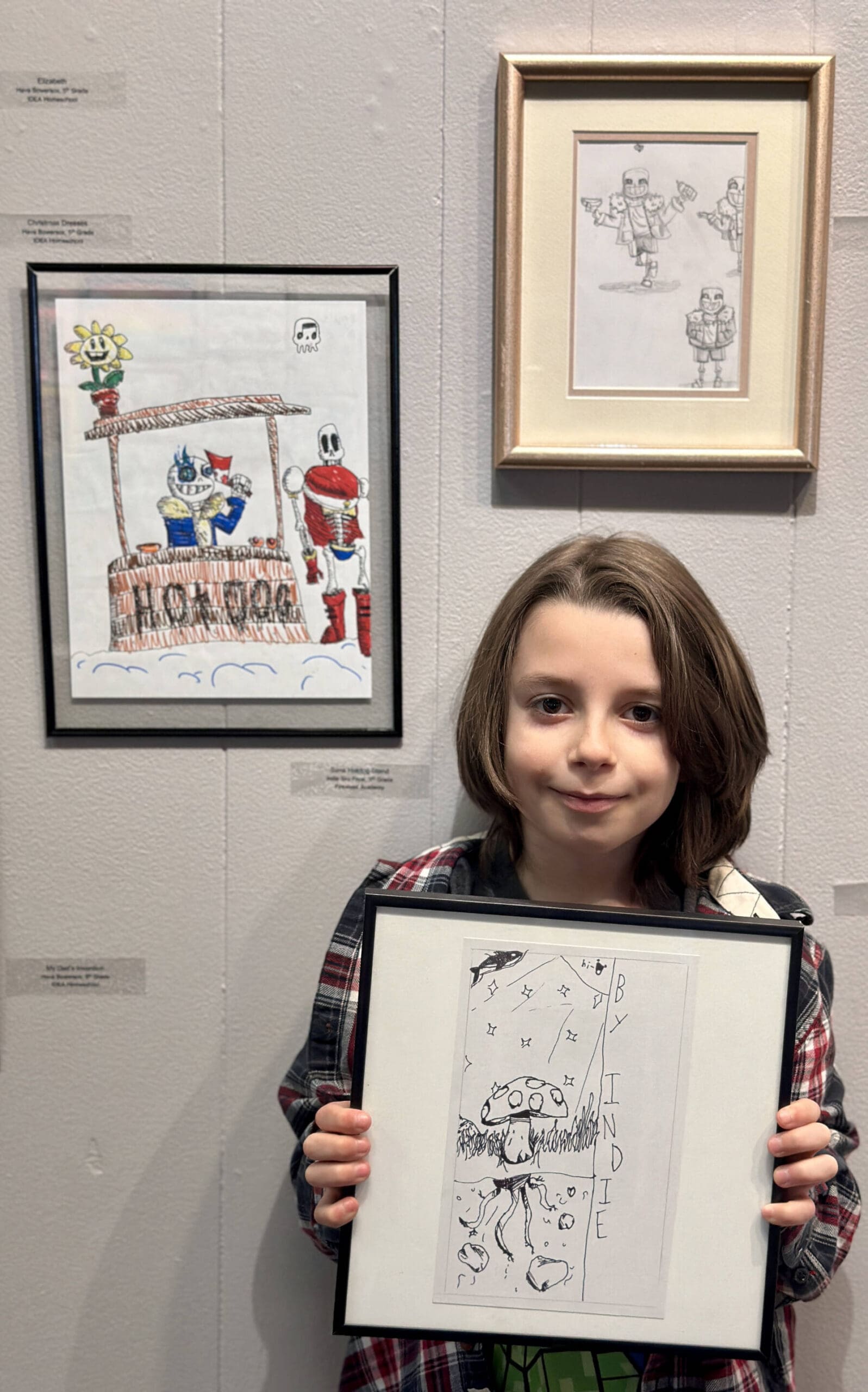 Indie Frost, 9, poses with his drawings that are on display in Homer Council on the Arts’ annual Jubilee Youth Arts exhibit on Monday, April 15, 2024 in Homer, Alaska. Photo by Christina Whiting