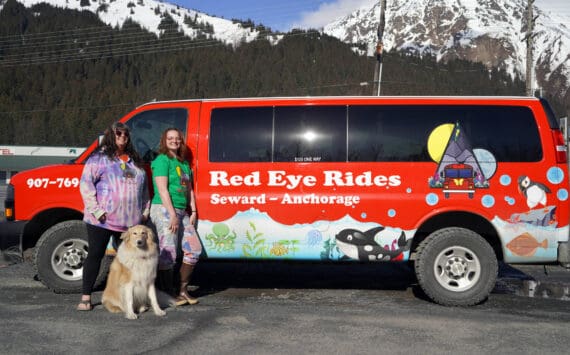 Angel Patterson-Moe and Natalie Norris stand in front of one of their Red Eye Rides vehicles in Seward, Alaska, on Wednesday, April 24, 2024. (Jake Dye/Peninsula Clarion)