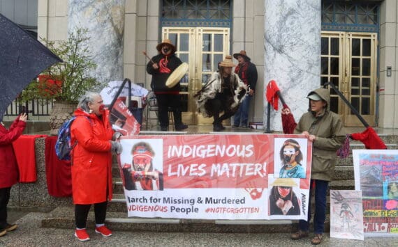 Advocates on behalf of missing and murdered Indigenous persons hold a banner and perform a opening song during a rally in front of the Alaska State Capitol on Sunday, May 5, 2024, to commemorate the annual Missing and Murdered Indigenous Persons Awareness Day. (Mark Sabbatini / Juneau Empire)